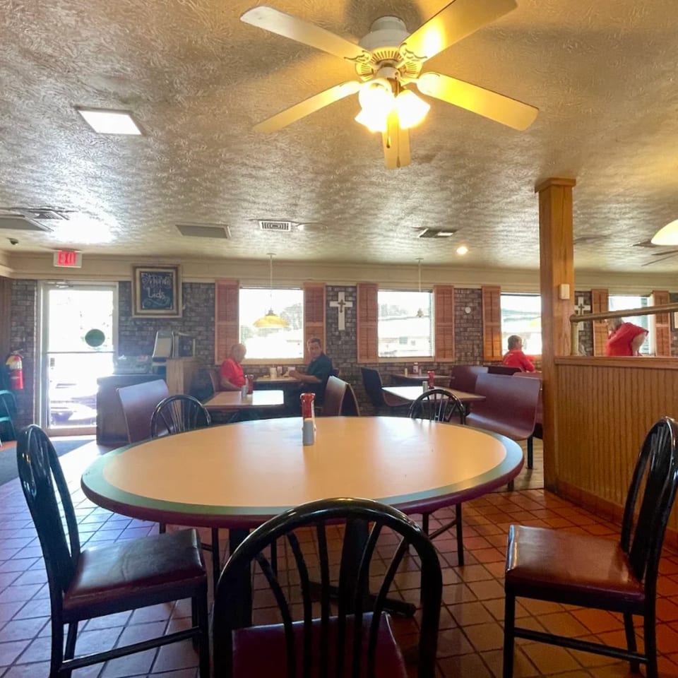Interior of Jim Bob's Chicken Fingers with tables, chairs, and a few customers dining.